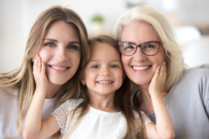 Portrait of girl hugging mom and grandmother making family pictu